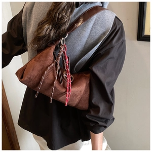 Vue détaillée du sac bandoulière en daim marron avec gland en corde rétro et cuir