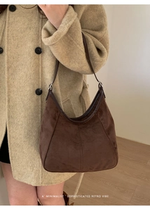 Gros plan du sac hobo minimaliste en daim marron avec garniture en cuir sur le mannequin