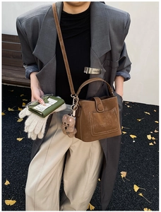 Brown frosted bucket bag detail with adjustable shoulder strap and cute teddy bear charm