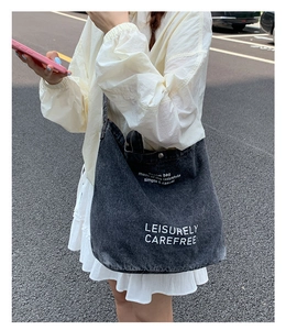Photo en extérieur d'un sac cabas en denim gris délavé vintage avec texte sur un mannequin