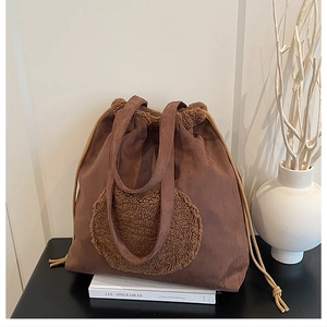 Detail of suede bucket bag with drawstring closure and plush teddy fur accent in dark brown