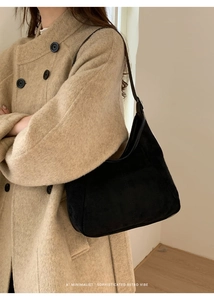 Vue détaillée du sac hobo noir mat porté avec un manteau beige pour un style rétro