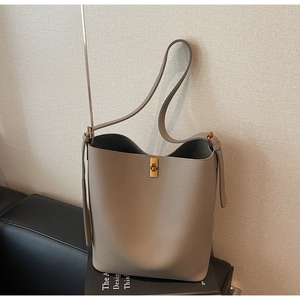 Détail du sac seau gris motif litchi avec fermoir doré et fine bandoulière réglable