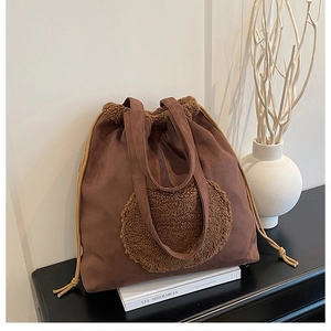 Detail of vintage coffee brown suede tote bag with drawstring and plush circle design