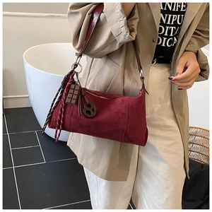 Détail du sac polochon en daim bordeaux avec breloques chocolat et cordons déco