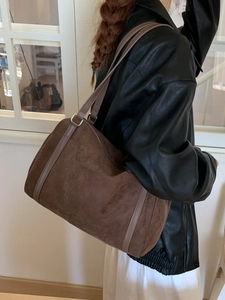 Sac fourre-tout vintage en daim marron foncé avec passepoil en cuir sur un mannequin