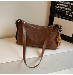 Détail du sac bandoulière léopard avec fermeture éclair argentée et breloque perlée