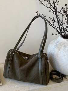 Sac Boston en cuir dépoli vert olive avec poignées minimalistes sur surface texturée