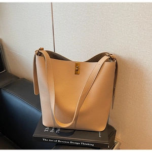 Détail du sac seau en cuir grainé beige avec un fermoir tournant en métal doré
