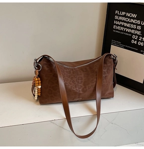 Détail du sac à bandoulière léopard avec pendentif en perles et fermeture éclair argentée