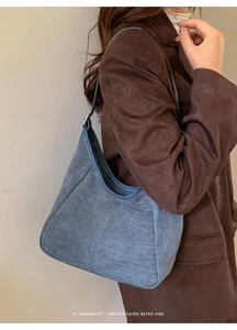 Détail du sac à bandoulière en daim bleu avec coutures contrastées et style minimaliste