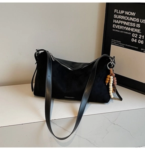 Détail du sac bandoulière en daim mat avec charm en perles léopard et zip argenté