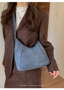 Gros plan du sac hobo en daim bleu avec coutures verticales et boucle en argent