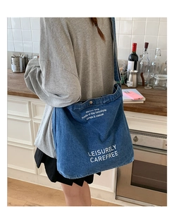Texture détaillée du cabas en jean bleu avec texte blanc dans un décor chaleureux