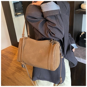 Detail of khaki vintage Boston bag with matte leather texture and metal lock decor