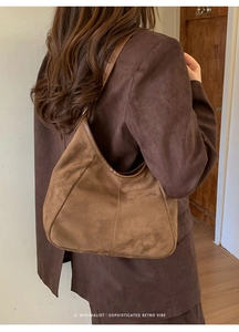 Détails rapprochés du sac hobo en daim marron avec coutures de qualité et texture rétro