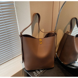 Détail d'un sac seau marron foncé en cuir grainé avec fermoir rotatif doré élégant