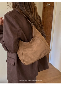 Vue détaillée du sac hobo en daim marron mat sur l'épaule pour un style rétro minimaliste