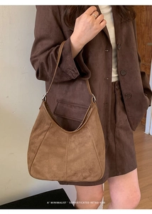 Détail du sac hobo en daim marron avec couture verticale et design rétro minimaliste