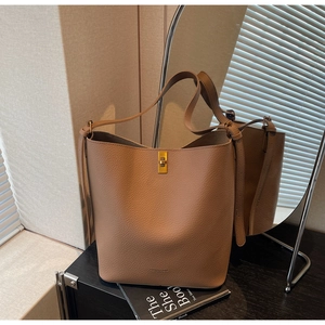 Détail du sac seau en cuir grainé kaki avec fermoir doré et logo de mode élégant