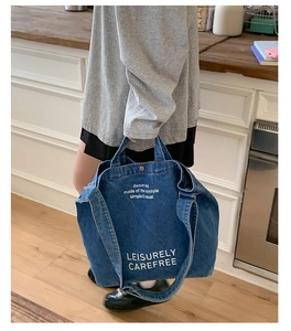 Détail d'un grand sac cabas en jean avec fermeture à pression et lettrage décontracté