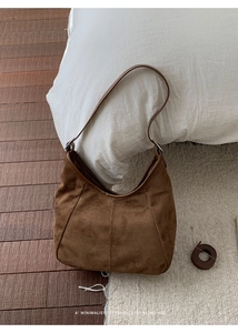 Gros plan sur la texture du sac hobo en daim marron avec une ambiance rétro chic