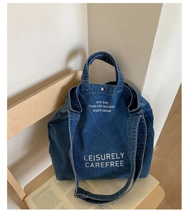 Détail du sac cabas en jean vintage avec boucle en métal sur une chaise en bois