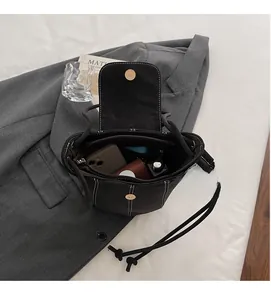 Intérieur spacieux du sac seau en daim noir montrant un grand espace de rangement