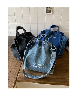 Trois sacs cabas en denim noir et bleu sur une table en bois pour un look décontracté
