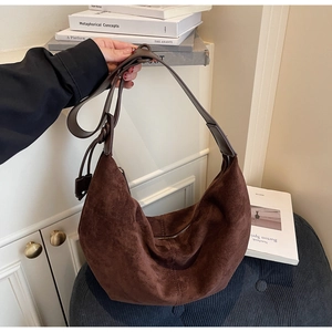 Detail of soft brown suede hobo bag with zip closure and leather shoulder strap