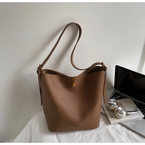 Vue détaillée du sac seau en cuir marron grainé dans un décor de bureau élégant