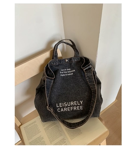 Détail du fermoir en métal et du denim délavé sur le grand sac fourre-tout gris