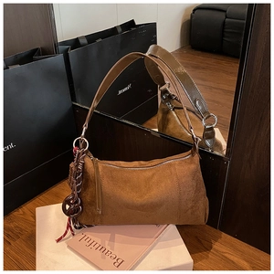 Gros plan détaillé du sac en daim marron avec fermeture éclair et charm nœud