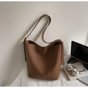 Détail du sac seau en cuir grainé marron avec fermoir rotatif en métal doré