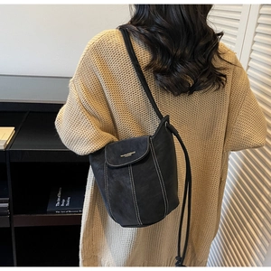 Détail du sac seau noir mat avec surpiqûres blanches contrastées et design épuré