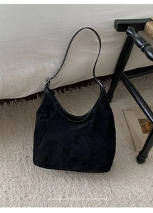 Détail du sac hobo en daim noir minimaliste avec bandoulière à boucle métallique réglable