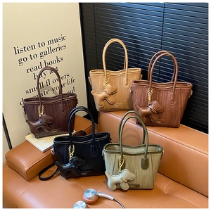 Detailed view of woven straw tote bags in five colors with cute leather dog charms