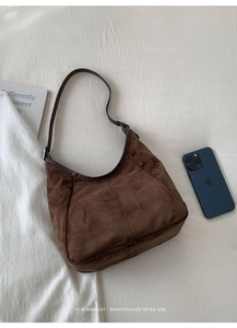 Détail du sac hobo en daim marron avec bandoulière en cuir et plis souples