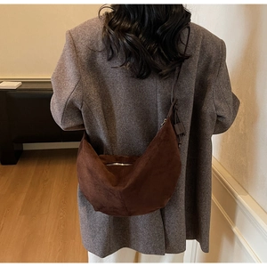 Detail of dark brown suede crescent hobo bag with premium texture and metal zipper