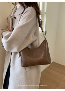Detailed side view of a brown retro leather bucket bag with decorative white beads