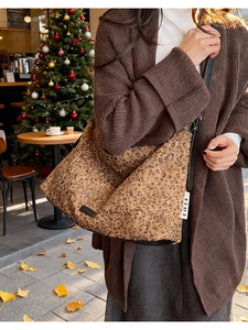 Gros plan du sac cabas léopard avec lanières en cuir noir dans un décor d'automne