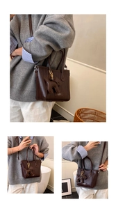 Detail of dark brown woven texture tote bag featuring a cute dog charm and slim shoulder strap