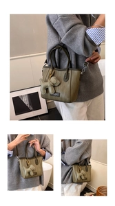 Detail view of woven olive green handbag with cute dog charm and stylish brand logo