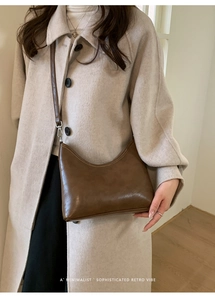 Detail showing high-quality dark coffee leather texture of this minimalist hobo bucket bag