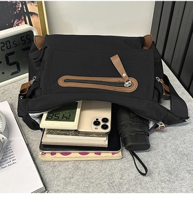 Interior view of black messenger bag showing large capacity with daily essentials