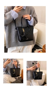 Close-up of black woven texture bucket bag with a cute dog charm and detachable strap