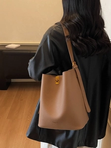 Sac seau en cuir marron grainé avec boucle dorée et bandoulière pour un style élégant