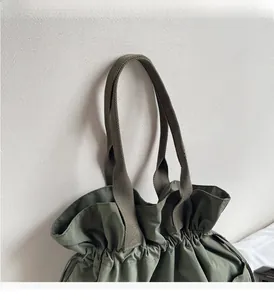 Detailed view of durable olive green nylon bucket bag with reinforced woven handles