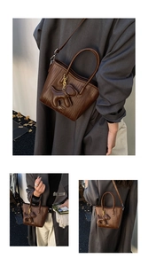Detail of dark brown woven texture small square bag with cute puppy bag charm accessory