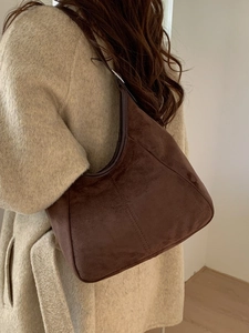 Sac seau hobo en daim marron avec coutures verticales et design minimaliste pour femmes